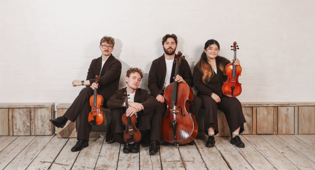 Elmore Quartet each with their instruments lined up against a wall