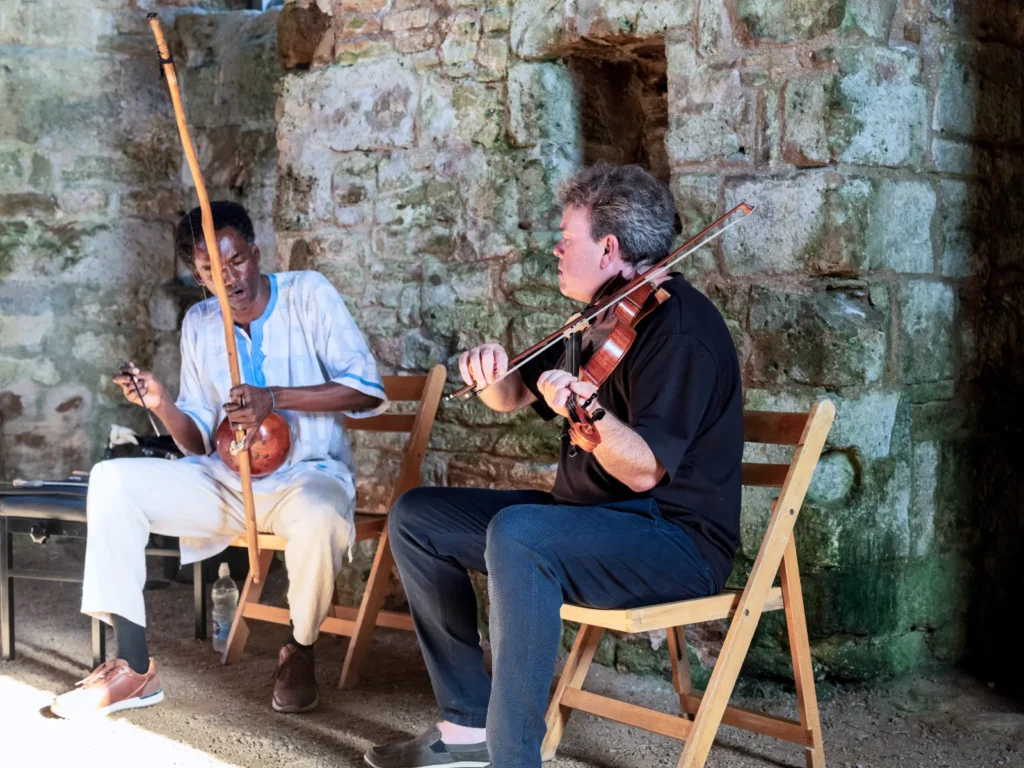 Adriano Adewale and Gareth Lubbe performing in a chapel